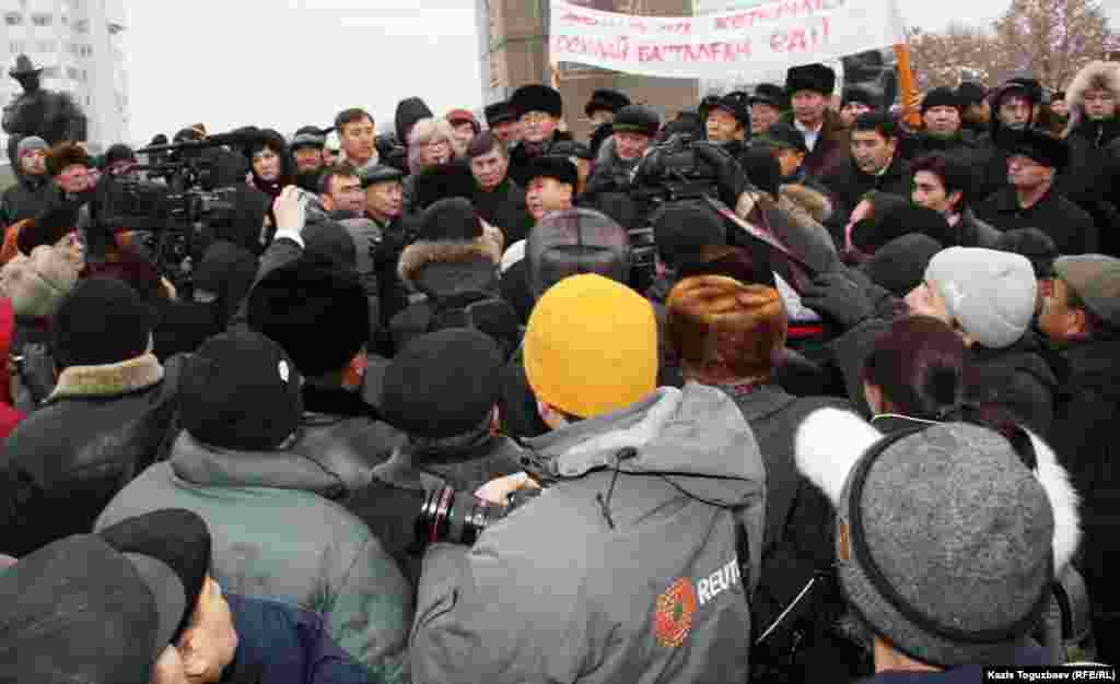 Некоторые оппозиционные активисты и политики выступают в связи с событиями в Жанаозене. Позади держат транспарант с надписью: "Так начинался Желтоксан".