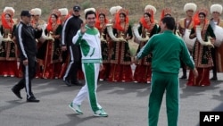 Turkmen President Gurbanguly Berdymukhammedov (center) waves to the media during the starting ceremony of a 500-day nationwide horse race at the historical site of Nisa just outside Ashgabat on May 5 in preparation for the 2017 Asian Indoor and Martial Arts Games.