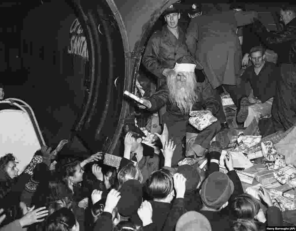 Подаръци за най-нетърпеливите от Дядо Коледа. Снимката е от 15 декември, 1948 г., на летище Темпелхоф. Този американски самолет е натоварен с подаръци от Ню Йорк и е първият от организираната от военновъздушните сили на САЩ "Операция Дядо Коледа".