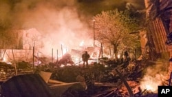 Ukrainian emergency workers deal with the aftermath of a Russian drone strike on Kharkiv late on April 29.