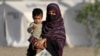 Afganistanka drži dijete dok stiže iz Pakistana u improvizirani kamp blizu afganistansko-pakistanske granice Torkham u provinciji Nangarhar 20. aprila