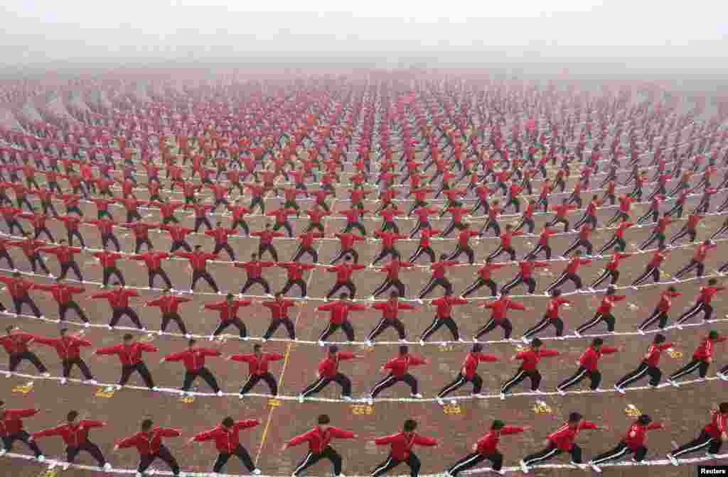  Рагъулал тайпабазул Shaolin Tagou школаялъул футболалъул команда гIуцIиялъул церемониялда китаялъул студентал. (Reuters/China Daily)