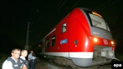Police stand by a regional train in Germany where an Afghan man wielding an ax attacked passengers.