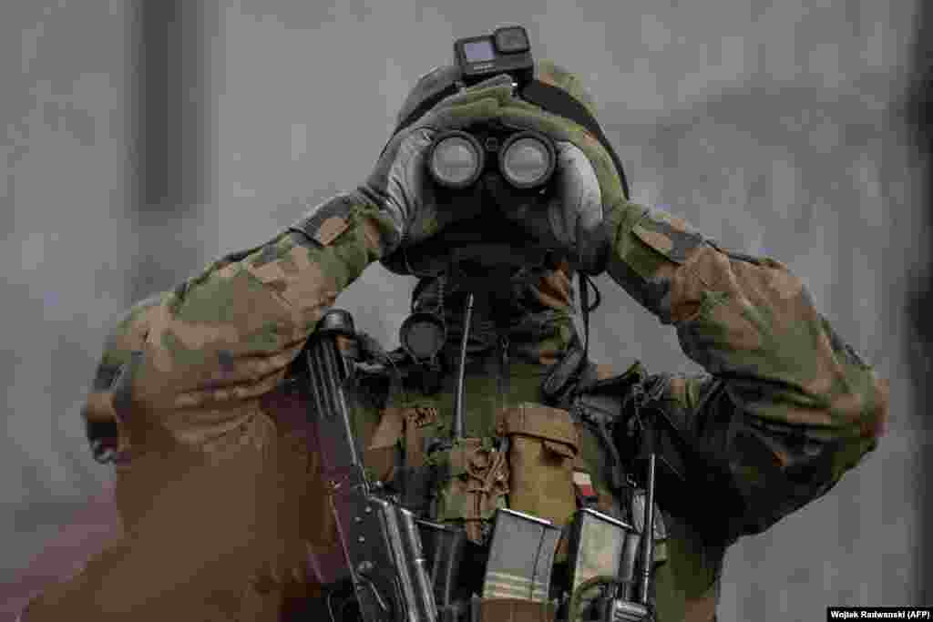 A Polish soldier looks through binoculars during a patrol of the country's border with Belarus.