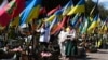 У велікодную нядзелю сям'я моліцца перад магілай загінулага ўкраінскага салдата на вайсковых могілках у Львове