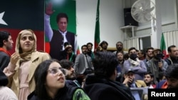 Supporters of former Prime Minister Imran Khan's Pakistan Tehreek-e-Insaf (PTI) party look on as they watch results on TV screens in Islamabad on February 8.