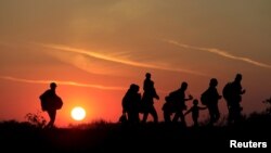 Венгрия менен Сербиянын чек арасында түн жамынып өтүп бараткан мигранттар. 30-август, 2015-жыл