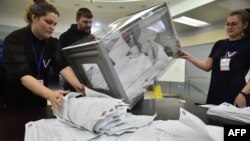 Membrii unei comisii electorale locale numără buletinele de vot la o secție de votare -Novosibirsk, Rusia, 17 martie.
