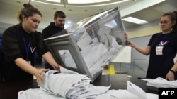 Членове на местната избирателна комисия броят бюлетините в избирателна секция в Новосибирск, Русия, 17 март 2024 г.