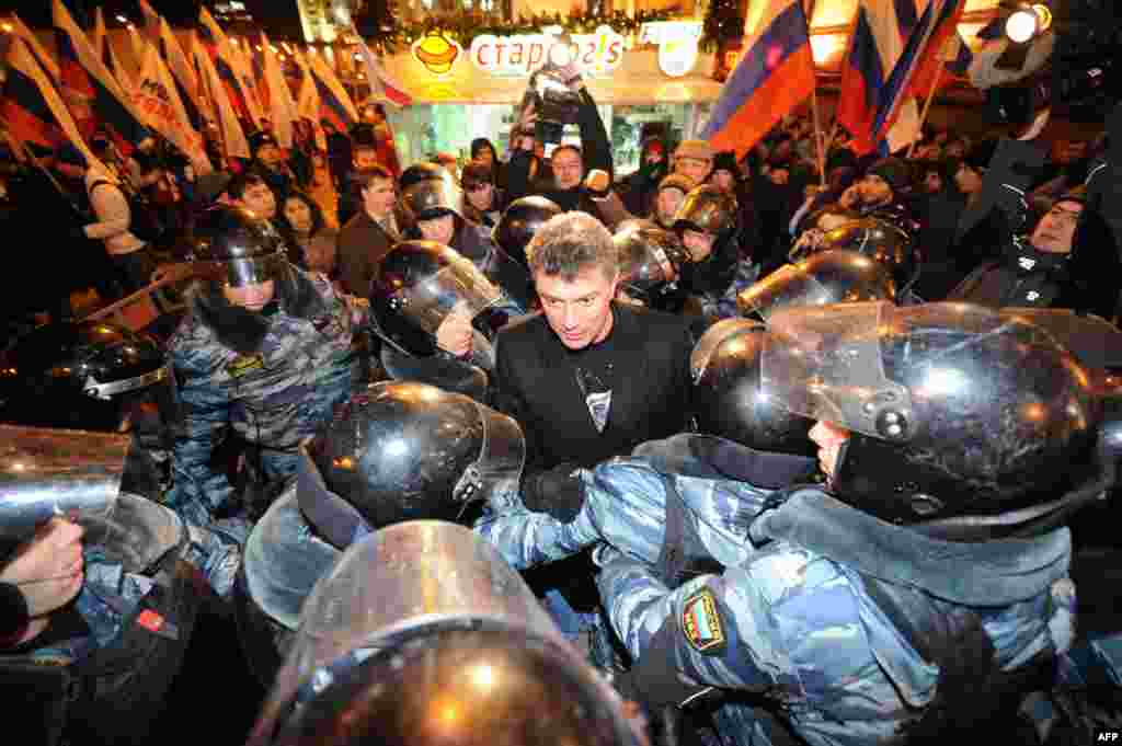 Полицията обкръжава Немцов, докато той говори по време на митинг срещу Путин в Москва през 2011 г. Тогава това е вторият масов протест в руската столица в рамките на дни. Исканията са за нови избори след предполагаема изборна измама.