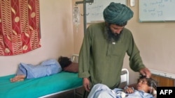 A man, Abdul Ghaffar, comforts his child, wounded in the attack, at a hospital in southern Kandahar city on July 24.
