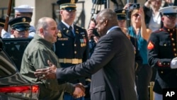 Secretarul american al Apărării Lloyd Austin (dreapta) îl salută pe ministrul ucrainean al Apărării Rustem Umerov la Washington, D.C. 2 iulie 2024.