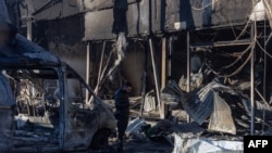 A man stands among debris next to a building destroyed after a drone attack in Odesa on March 8. 