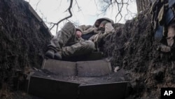 Un soldat ucrainean se odihnește într-un șanț de pe linia frontului lângă Liman, în regiunea Donețk, pe 29 martie.
