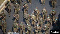 Військові М’янми просуваються вулицею зі щитами під час протесту проти військового перевороту в Янґоні, 28 лютого 2021 року