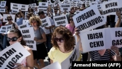 Aktivisti i aktivistkinje sa imenima nestalih na Kosovu tokom marša glavnim ulicama u Prištini, avgust 2018. 