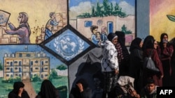 Raseljeni Palestinci u gradu Rafa na jugu Pojasa Gaze čekaju u redu da dobiju pomoć ispred centra agencije UN za pomoć paestinskim izbeglicama, 28. januar 2024.