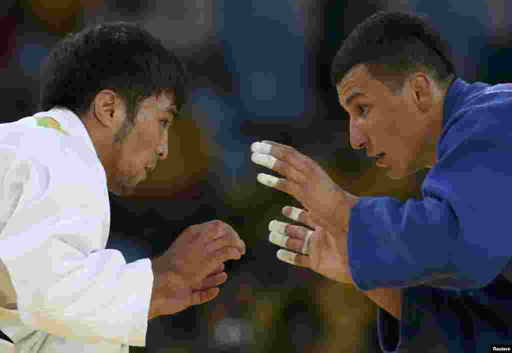 Yeldos Smetov (left) of Kazakhstan and Diyorbek Urozboev of Uzbekistan compete in the men's 60-kilogram judo competition.