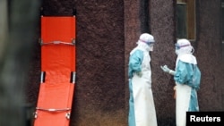 Zdravstveni radnici u zaštitnoj odjeći pored prostora za izolaciju u kojem se liječe oboljeli od virusa Marburg, u gradu Uige na sjeveru Angole (fotoarhiv)