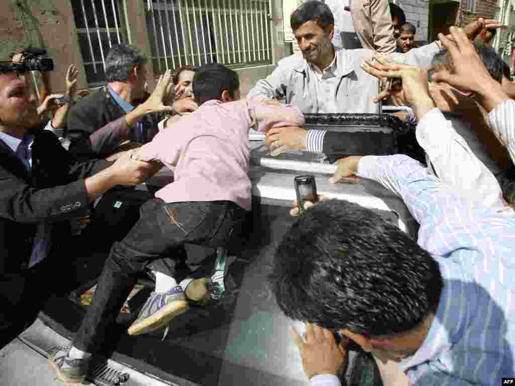 Supporters greet President Mahmud Ahmadinejad outside a polling station in Tehran.