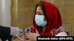 يوه مېرمن د کورونا وایرس ضد واکسين لګوي