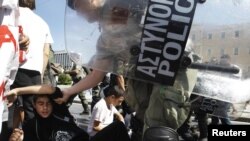 Riot police remove student protesters during an antiausterity demonstration in Athens.