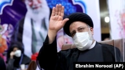 Ebrahim Raisi waves to journalists while registering his candidacy for the upcoming presidential election at the Interior Ministry in Tehran on May 15. 