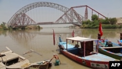 A man wades next to his boat along the Indus River near the Lansdowne Bridge in Sukkur, in Pakistan's southern Sindh Province on April 28.