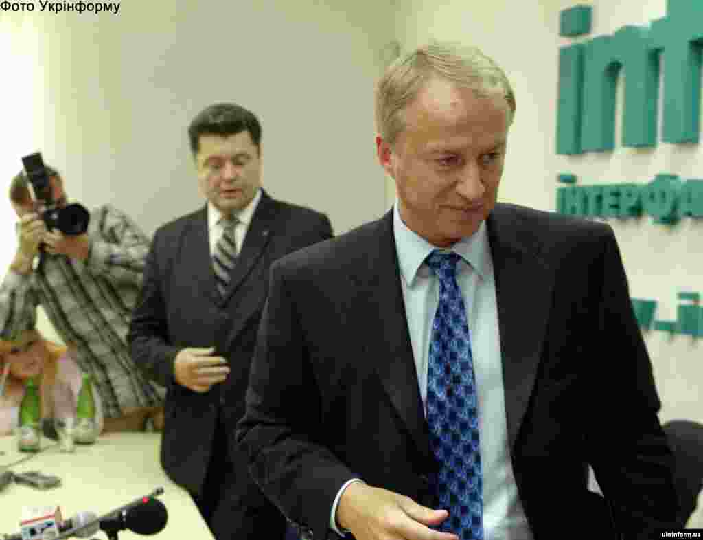 У 2005 році тодішній держсекретар Олександр Зінченко звинуватив Петра Порошенка, який обіймав на той час посаду секретаря РНБО, в корупції та вимагав від нього відокремлення бізнесу від влади. Зінченко переконував, що Порошенко контролює правоохоронні органи та судову гілку влади з метою відстоювання своїх бізнес-інтересів. Через три дні після цих звинувачень Порошенко оголосив про свою відставку. Тоді проти нього відкрили кримінальну справу, але згодом суд не встановив фактів злочину і зобов’язав Зінченка спростувати свою заяву. На фото: З журналістами після прес-конференції колишнього державного секретаря України Олександра Зінченка спілкувався секретар РНБОУ Петро Порошенко. Київ, 5 вересня 2005 року