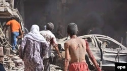 People flee the site of a bombing in the Kurdish city of Qamishli, near the Turkish border on July 27.