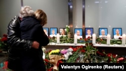 Relatives of the flight crew members of the UIA plane that crashed in Iran mourn at a memorial at Boryspil International Airport outside Kyiv.