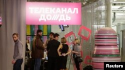 Журналисты телеканала "Дождь" выходят из здания после конференции. Москва, февраль 2014 года.