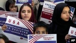 Afghan refugees in the Pakistani capital, Islamabad, hold placards during a meeting earlier this year to discuss their situation after US President Donald Trump paused refugee programs.