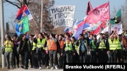 Studenții cu steaguri ale Serbiei și ale departamentelor universitare a în timp ce merg la un protest la Kragujevac, Serbia, pe 15 februarie.