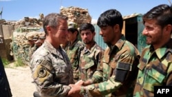 Scott Miller, commander of U.S. and NATO forces in Afghanistan (left), shakes hands with Afghan National Army soldiers while visiting a checkpoint in the Nerkh district of Wardak Province. (file photo)
