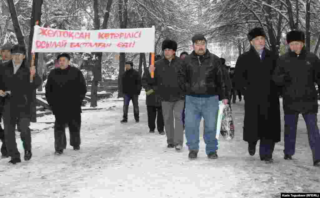 Политик Хасен Кожо-Ахмет вместе с сторонниками идут к зданию президентской партии "Нур Отан" выразит протест против жесткого подавления акций в Жанаозене.