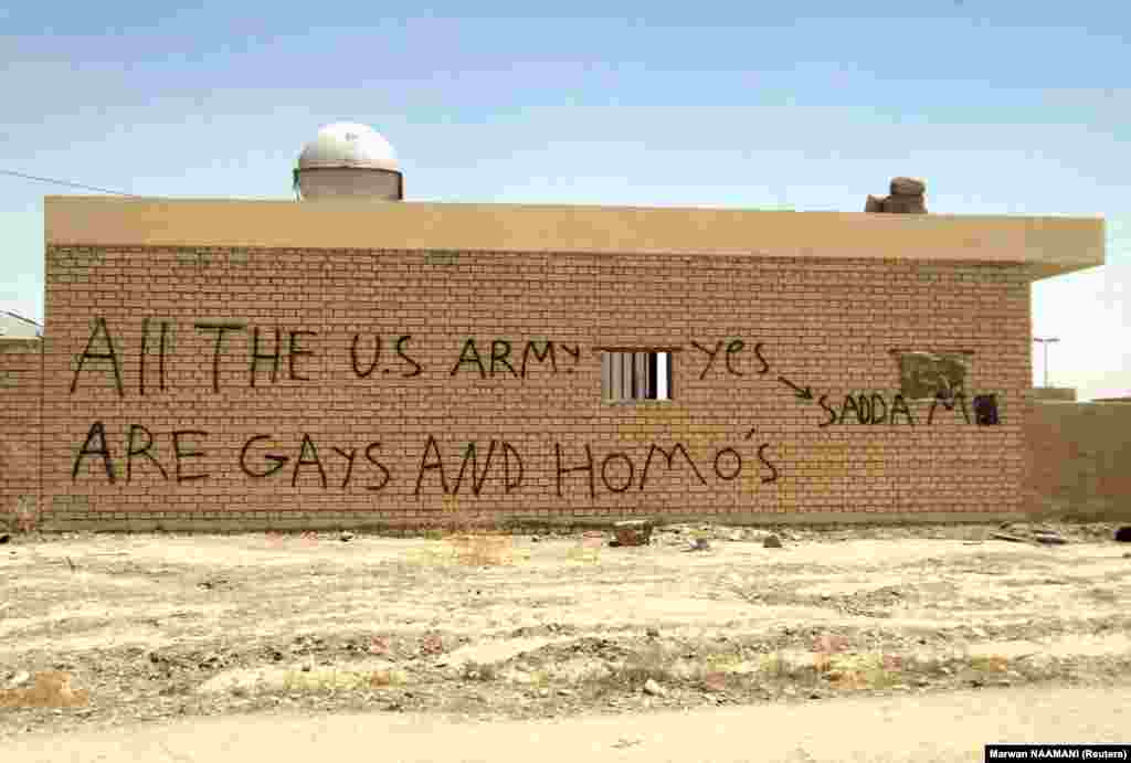 Grafit "Svi u američkoj vojsci su gay i homići" na zidu kuće u Tikritu, granatirane 2003. godine tijekom američke invazije. Ovaj irački grad je rodno mjesto bivšeg diktatora Sadama Husseina.
