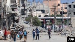 Jurnaliști în fața clădirilor distruse din tabăra Jabalia pentru refugiați palestinieni din nordul Fâșiei Gaza, pe 9 octombrie 2024.