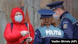 Жена показва документите си на полицията, която контролира спазването на карантината в Букурещ, намиращ се на 360 км. от Сучава