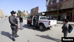A boy looks on while waiting for soldiers to finish searching a vehicle and his father at a checkpoint in central Baghdad ahead of the Arab League summit later this week. 