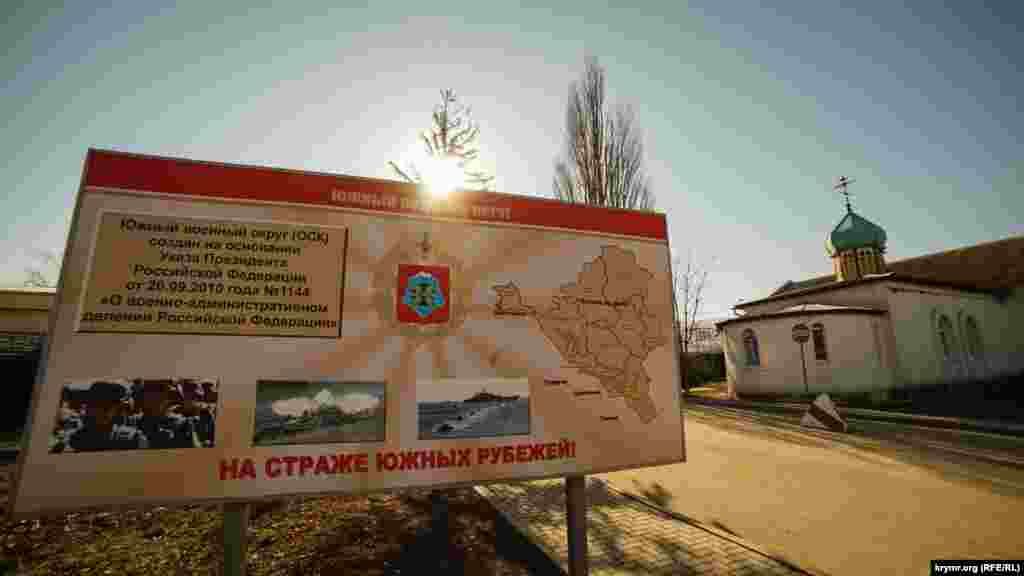 У КПП российской военной части. Справа – бывший (до аннексии) храм Покровы пресвятой Богородицы УПЦ КП. Он открылся в 1996 году, став, по сути, первым в отечественной истории гарнизонным храмом ВС Украины