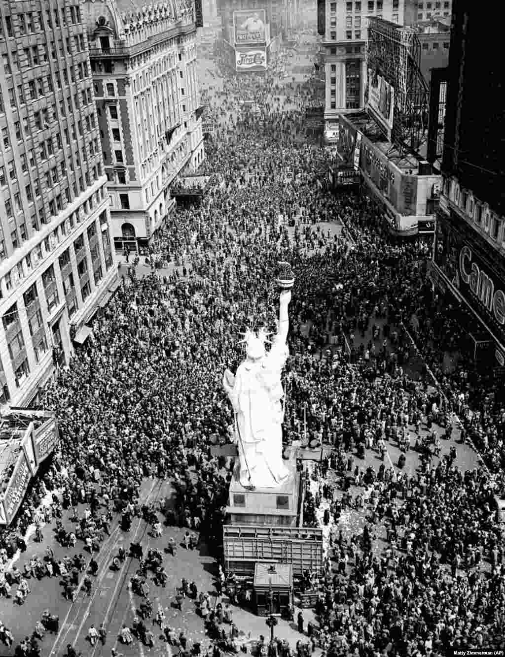 Mulțimi de oameni sub o replică a Statuii Libertății din Times Square. Un reporter a descris scena: „ În anumite locuri, un civil- uneori un ospătar- oferea băuturi străinilor. Băuturile au fost acceptate, cu nerăbdare, în mare parte de adolescenți. ”