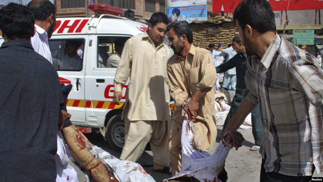 Volunteers carry a victim to an ambulance from the site of a suicide attack during a Shi'ite procession in Quetta.