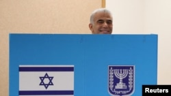 Predsednik prelazne vlade Izraela Jair Lapid smeši se fotografima iza glasačke kabine na biralištu u Tel Avivu, 1. novembar 2022.