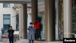 Kinseki službenici fotografišu fotografa ispred hotela u Vuhanu gdje su smješteni članovi tima Svjetske zdravstvene organizacije, 15. januar, 2021. 