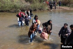 Sirijski Alaviti, koji su pobjegli od nasilja na zapadu Sirije, hodaju kroz vodu rijeke Nahr al-Kabir u Akkaru, Liban, 11. marta.