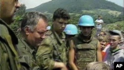 Optuženi za ratne zločine i genocid Ratko Mladić razgovara sa dječakom Izudinom Alićem u Potočarima , jula 1995