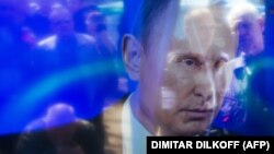 Președintele rus, Vladimir Putin, reflectat pe ecranul unei camere foto în timp ce se afla la o emisiune televizată