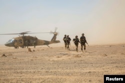 Ооганстандын коопсуздук күчтөрү Black Hawk тик учагынан түшүүдө.