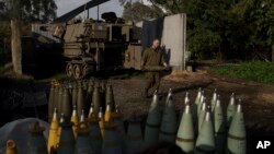 Israel, granița cu Libanul. Un soldat israelian duce un obuz. Perspectiva unui război Israel-Hezbollah în Liban îi îngrijorează pe locuitorii aflați de ambele părți ale graniței, dar unii o privesc ca pe o consecință a războiului dus de Israel împotriva Hamas în Gaza. 